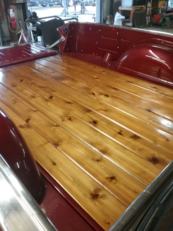 Finished cedar tongue & grove truck bed floor with polished strips over maroon paint